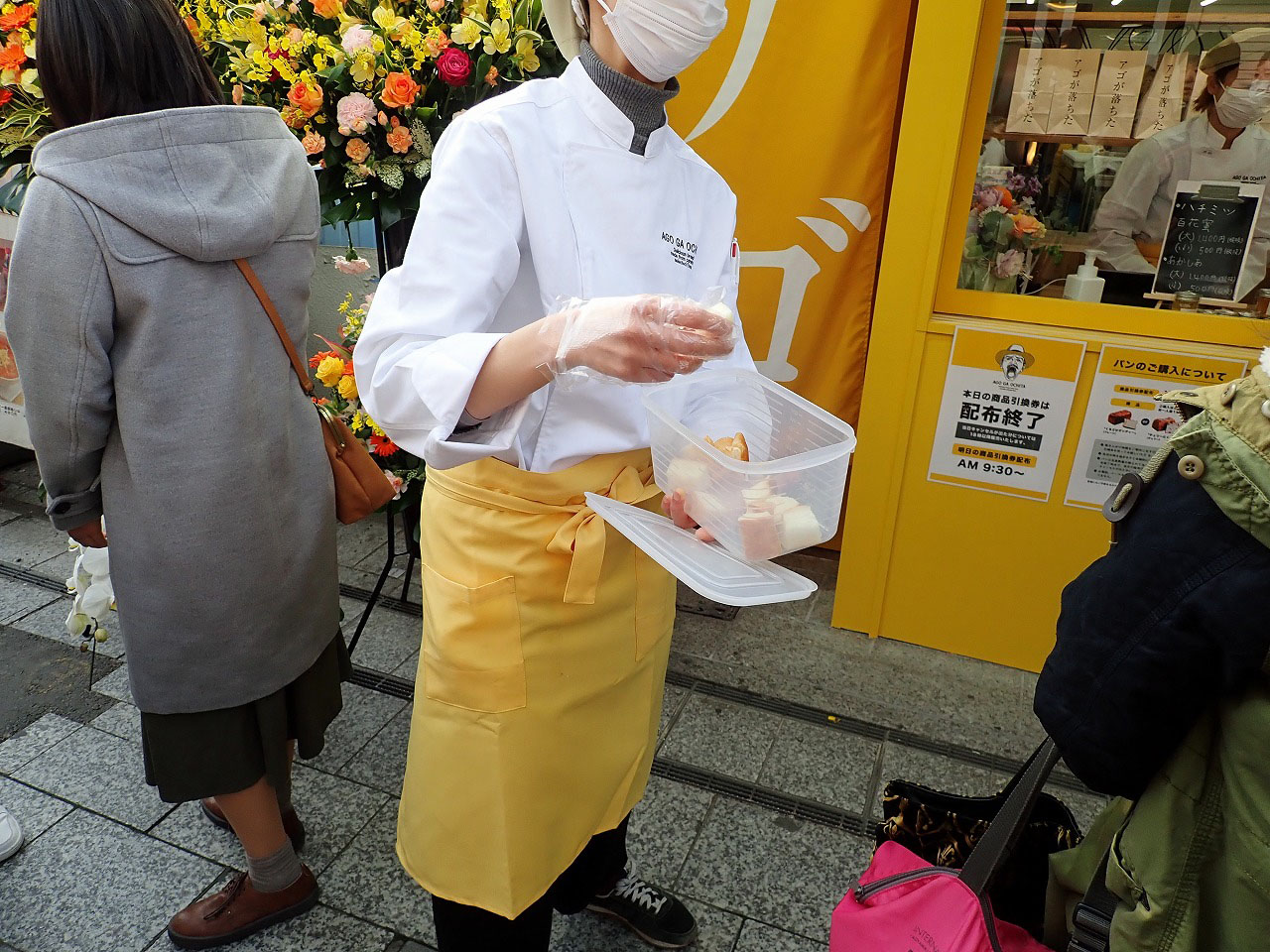 高級食パン専門店『アゴが落ちた』の店前で切り分けたパンをサービスするスタッフの方