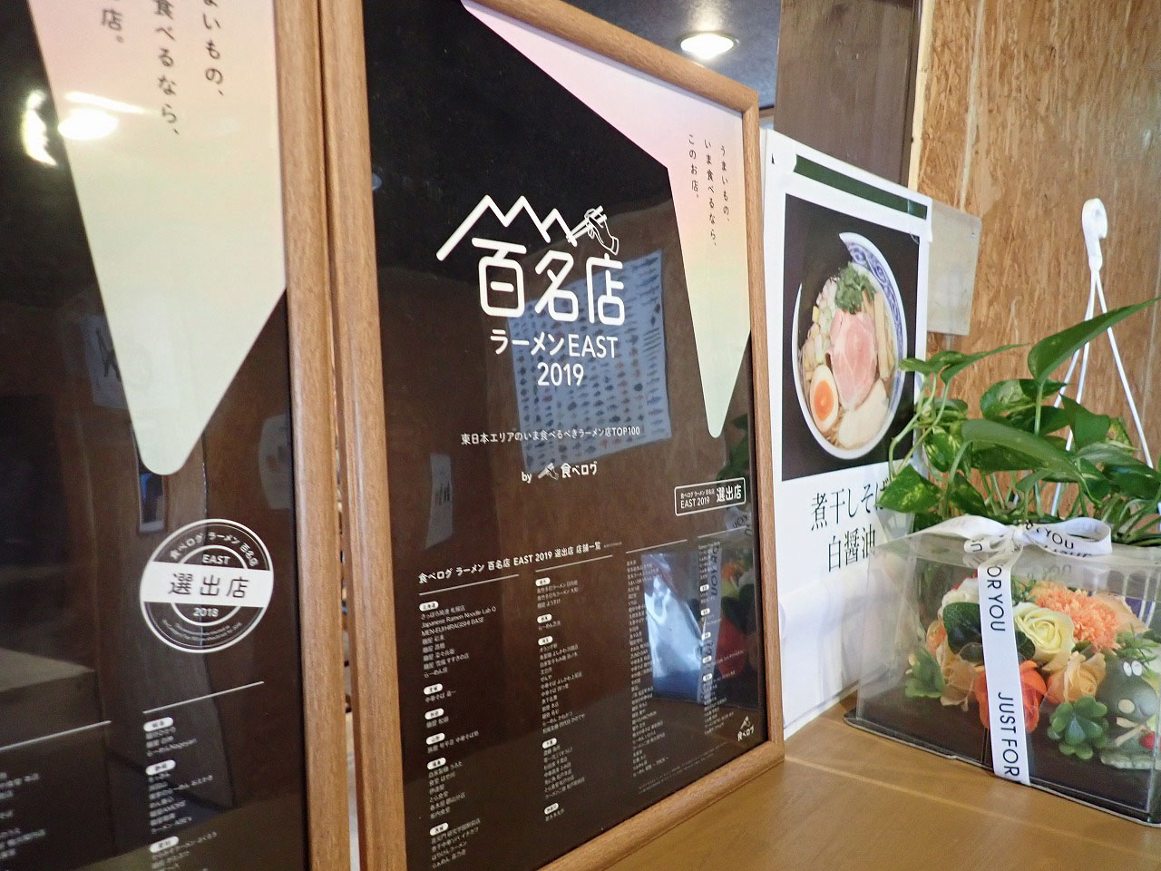 『寿製麺よしかわ』の店内に展示されている「ラーメン 百名店 EAST　2019」の案内