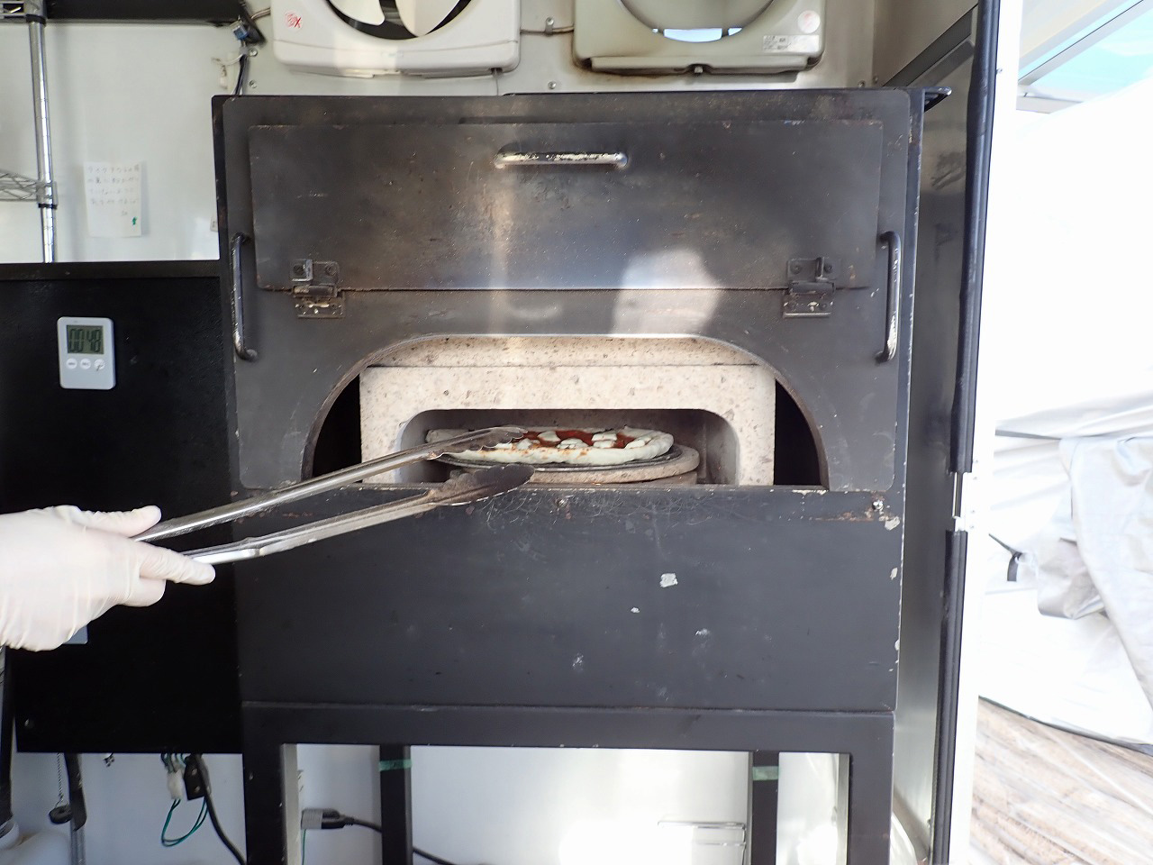 『ドライブスルー　ピッツァ　ウッドベイカーズ』のピザを焼いているところ